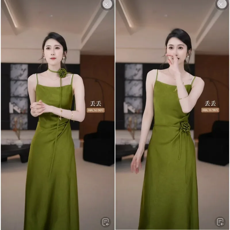 Damska sukienka maxi na ramiączkach spaghetti, z satyny w kolorze oliwkowej zieleni, z kwiatowym zdobieniem i marszczeniami, idealna na wieczorne przyjęcie.