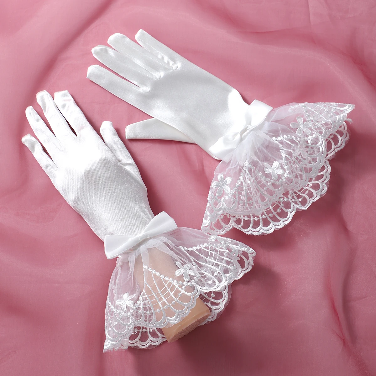 A pair of white fingered gloves suitable as accessories for bride weddings or women's dances