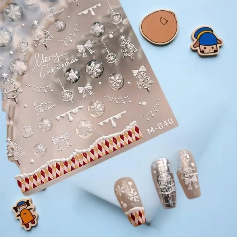 تصميم شجرة بيضاء ساحرة لعيد الميلاد مع ملصقات فنية للأظافر على شكل ندفة الثلج وأقواس حمراء تتميز بطباعة منقوشة