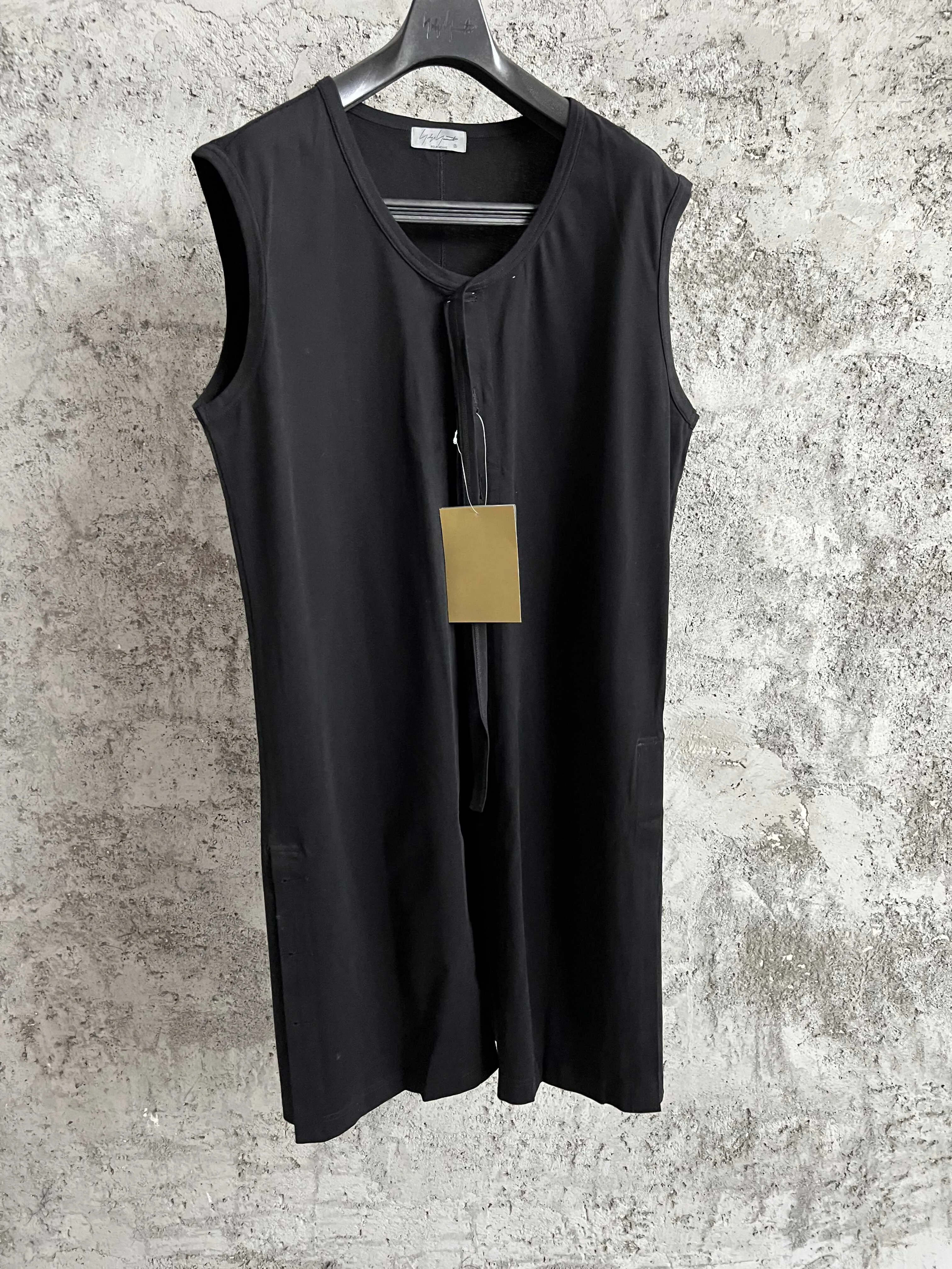 A black top for men with a round neck, a sleeveless long vest decorated with buttons and a pure cotton design