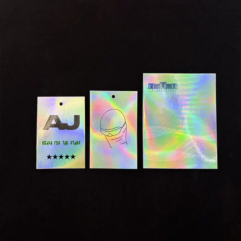 ป้ายแท็กแขวนเสื้อผ้าแบบกำหนดเอง 500 ชิ้น พิมพ์ลายโฮโลแกรมเลเซอร์สีเงินบนแผ่นฟอยล์ พร้อมป้ายแขวนกระดาษแข็งพิเศษสำหรับเสื้อผ้า