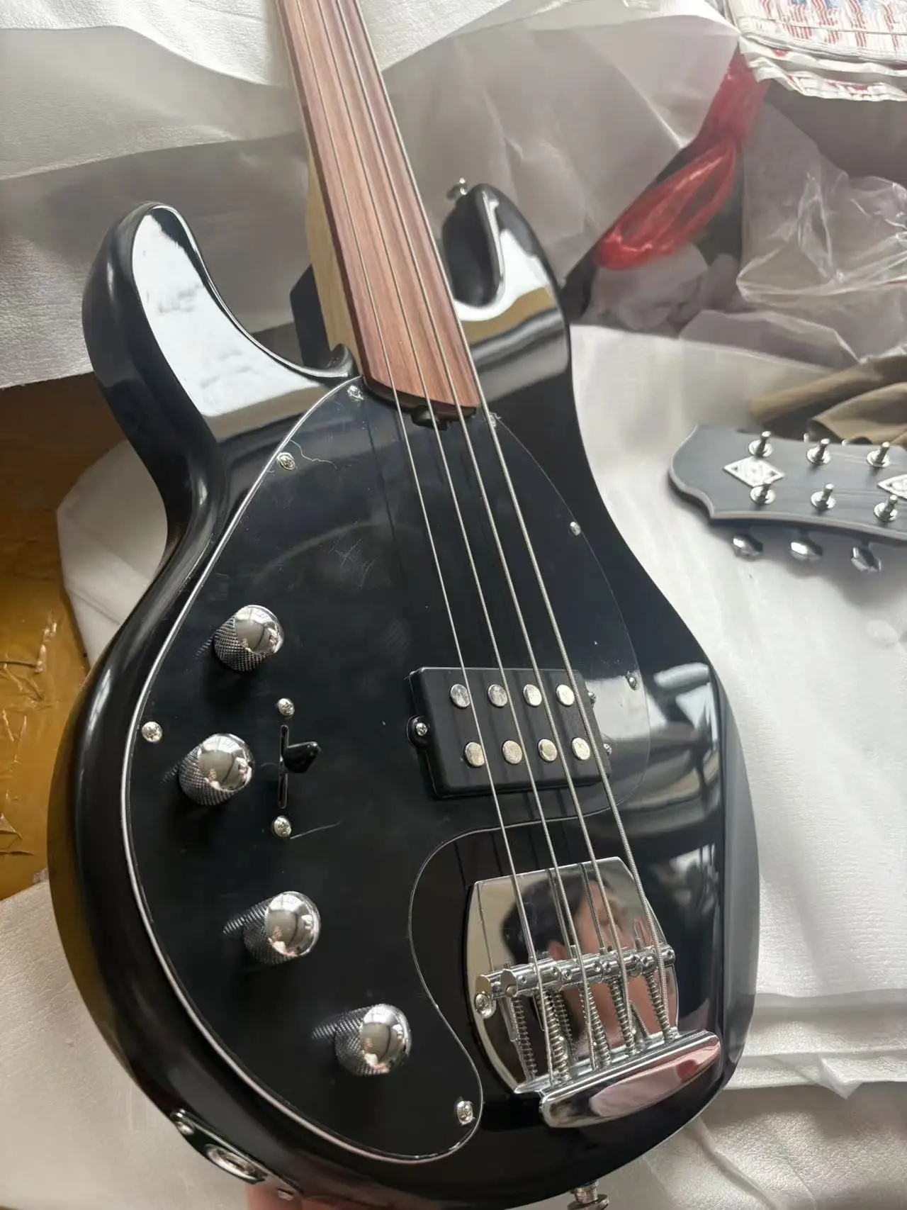 Left-hand 4-string bass, rosewood fingerboard without frets, high-gloss black body, with built-in electronic equipment,