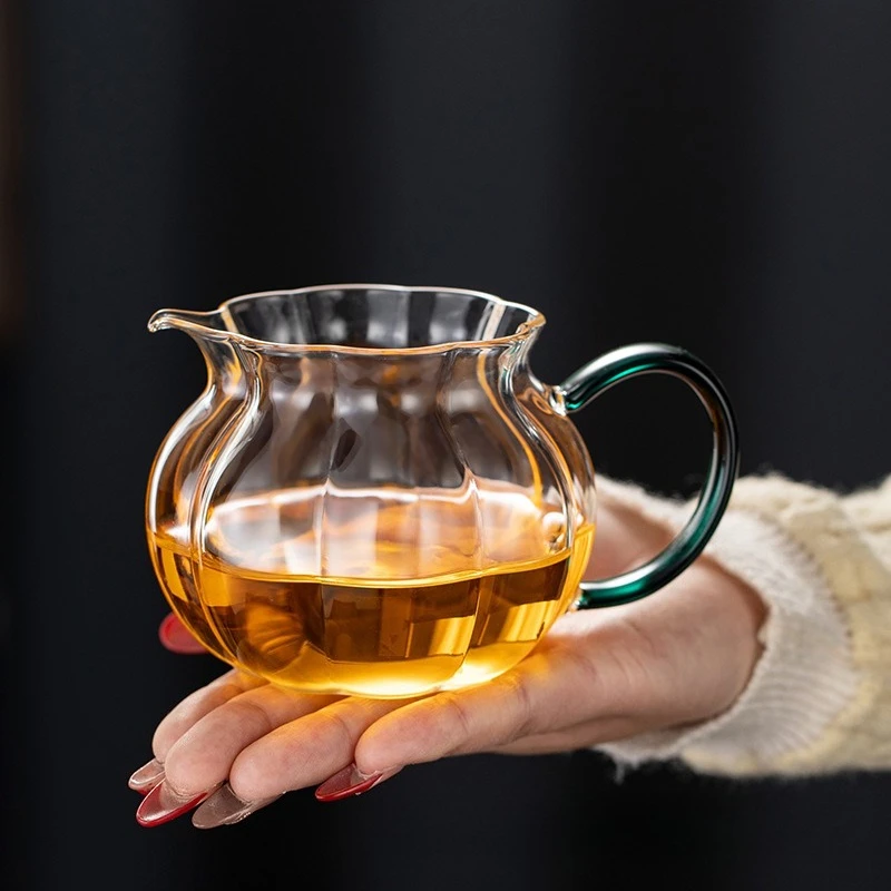 

Элегантный стеклянный чайник с цветной ручкой. Стильный кувшин для сервировки чая, идеально подходящий для заваривания и сервировки чая.