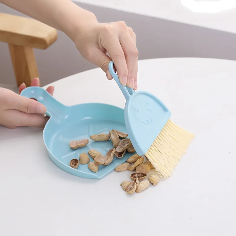 A set of mini tabletop brooms with smiley faces, garbage shovels