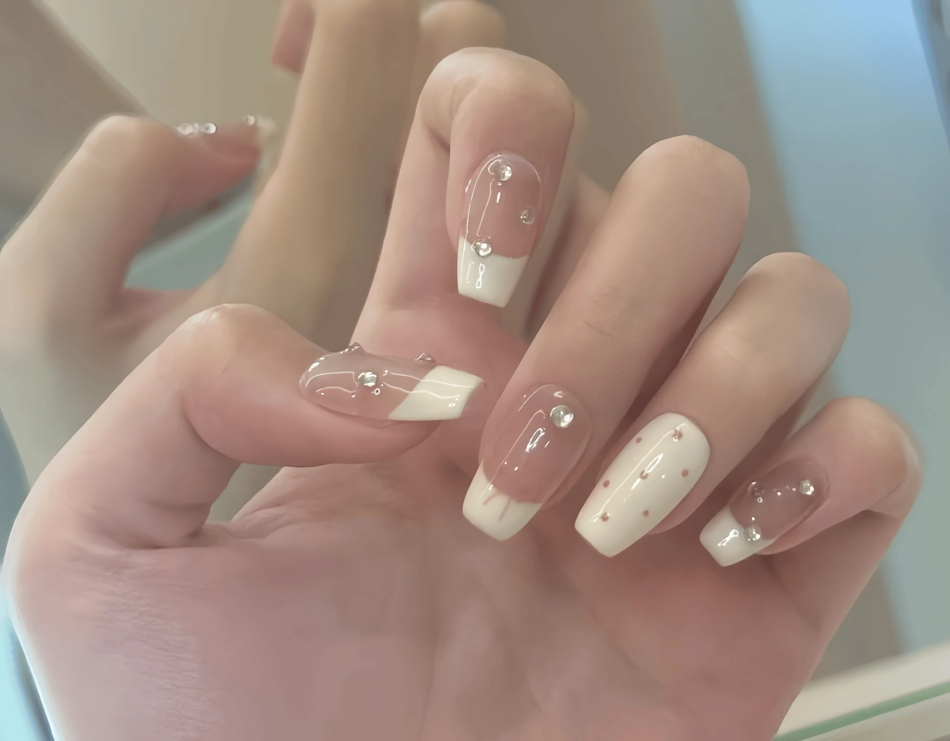 10 Stück handgefertigte, tragbare Nagelkunst mit vollständiger Abdeckung, mittellange Nägel, Nude-Farbton mit milchig-weißen French-Tips, kleinen roten Punkten und zarten Strassverzierungen, fein