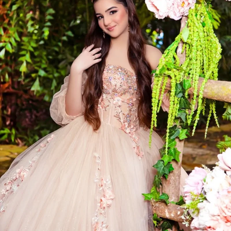 ชุดเดรสงาน Quinceanera สีแชมเปญอ่อน ประดับคริสตัลวิบวับ ลายดอกไม้ 3 มิติ พร้อมชายกระโปรงยาว ﻿ ปรับแต่ง