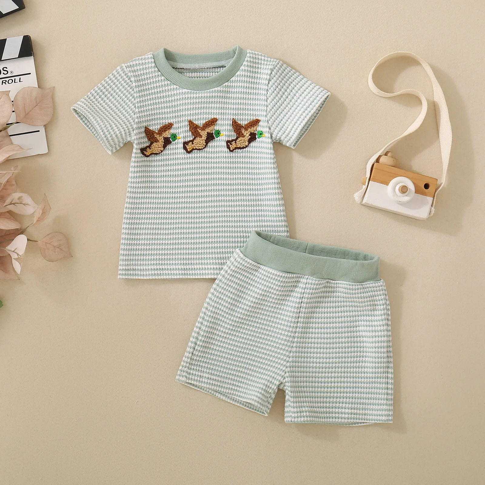 Summer unisex baby and toddler set comprising a light green striped short-sleeved top with bird embroidery and matching shorts