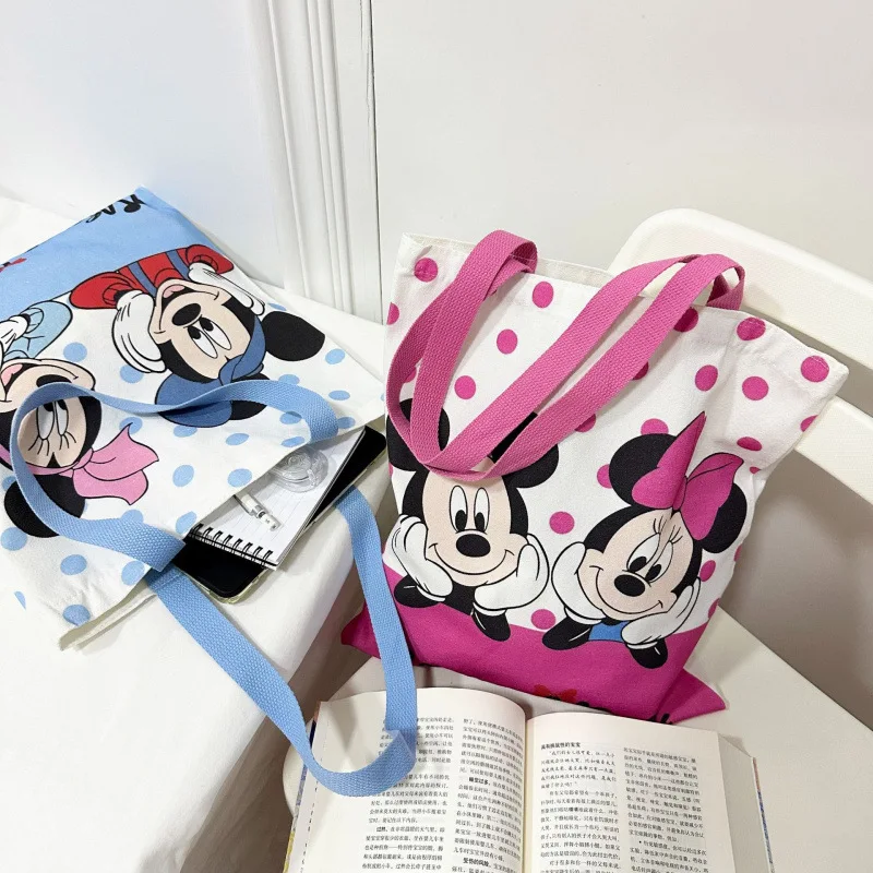 ใหม่ Kawaii Mickey Mouse ผ้าใบกระเป๋าอะนิเมะ Minnie Mouse อุปกรณ์เสริมกระเป๋าสะพายนักเรียนกระเป๋าเป้สะพายหลังการ์ตูนมือถือช้อปปิ้งกระเป๋า