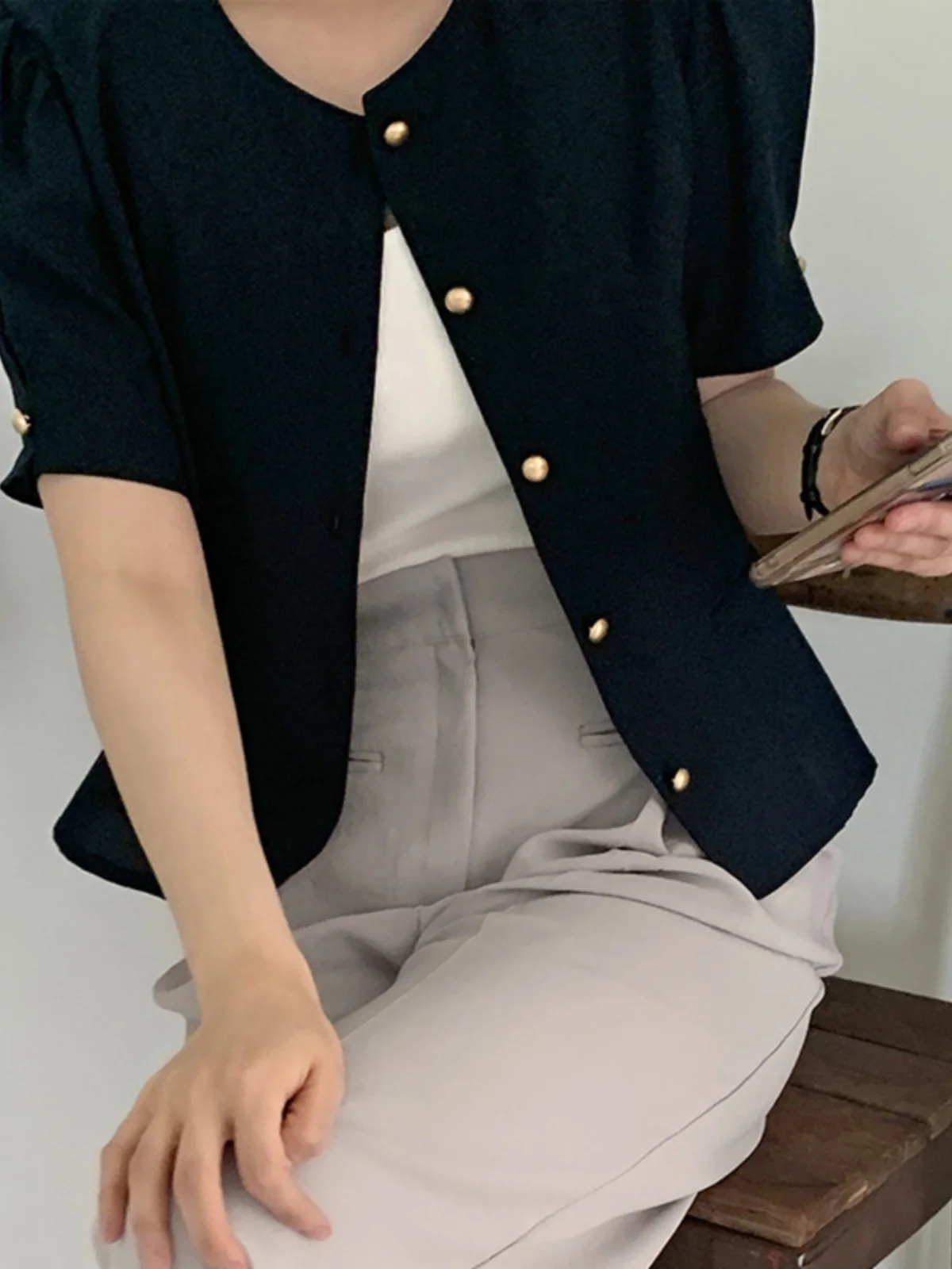 Elegancka damska sukienka w stylu vintage, delikatna, z pojedynczym guzikiem, bufiaste rękawy, podkreślona w talii, o długości midi, z kwiatowym wykończeniem.