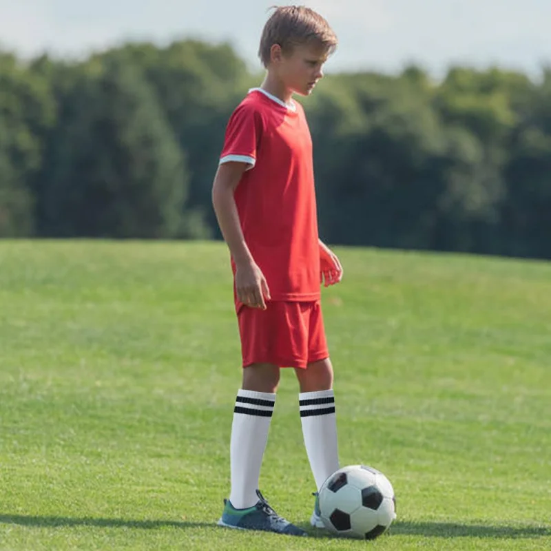 Erwachsene Fußballs ocken treffen farbige, verschleiß feste Kinder, die lange Socken über kniehohen Baseball-Hockeys ocken tragen