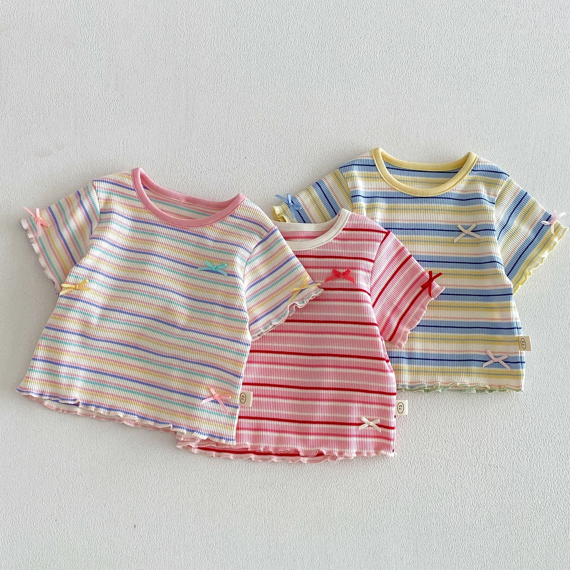 

Летняя детская футболка для девочек 2026 года (6М-5Т) с цветными полосками, изящными бантиками и рюшами по краю, на эластичной резинке