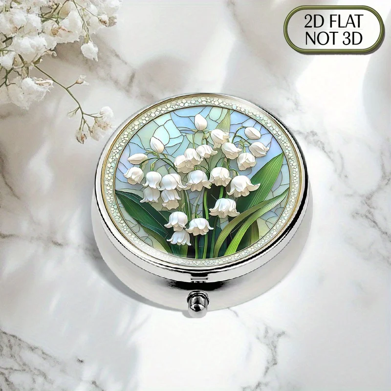 A flat, portable, round metal pill box, featuring an ultra-realistic and vividly painted glass lily of the valley design, suitable for home and travel use, perfect for storing medication, vitamins, multi-functional organizing accessories, coins, or as a prayer box, with a flat design