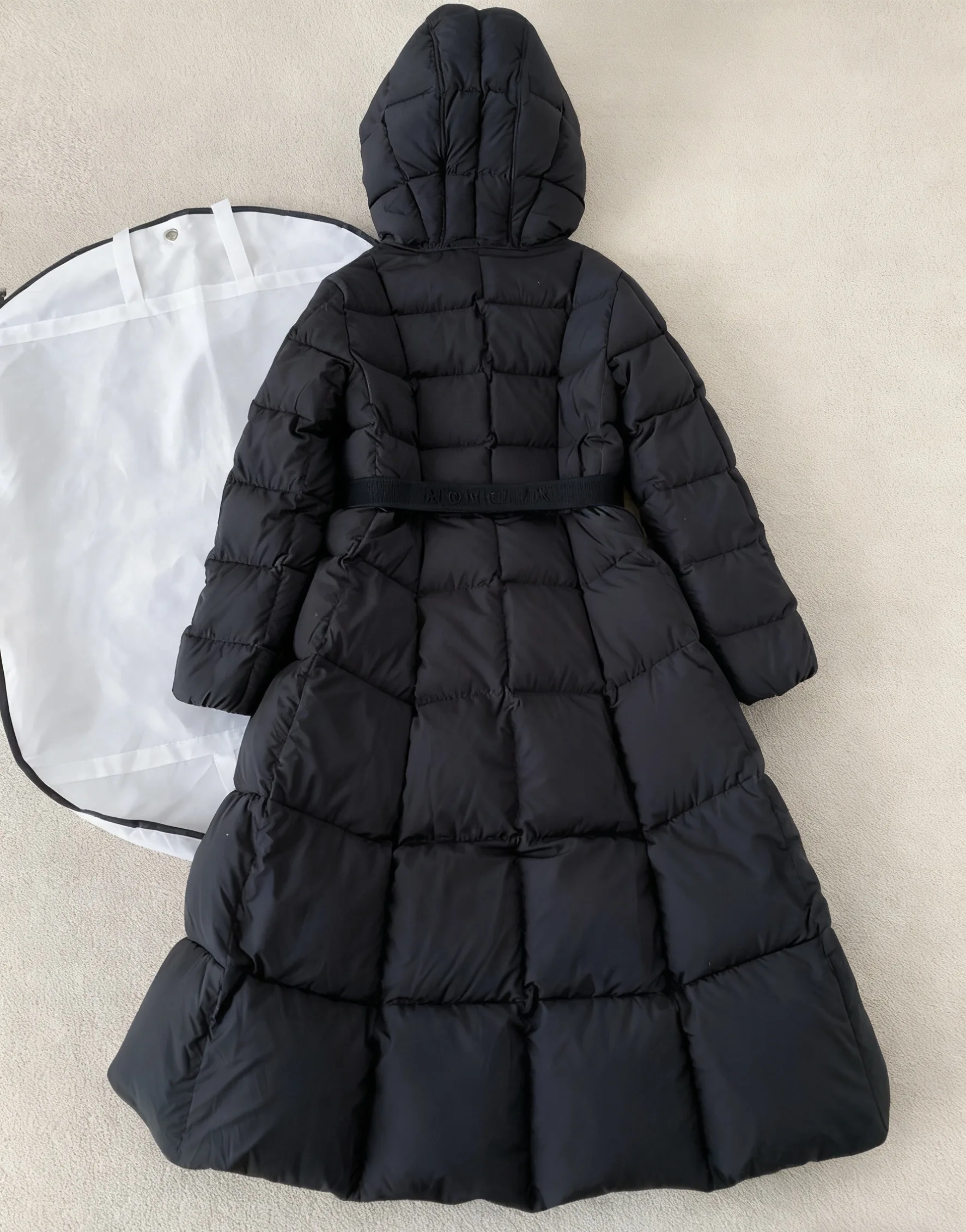 Długa czarna kurtka puchowa damska z kapturem, regulowanym sznurkiem w pasie, ocieplana, pikowana, pełnowymiarowa kurtka puchowa na zimę 2025.