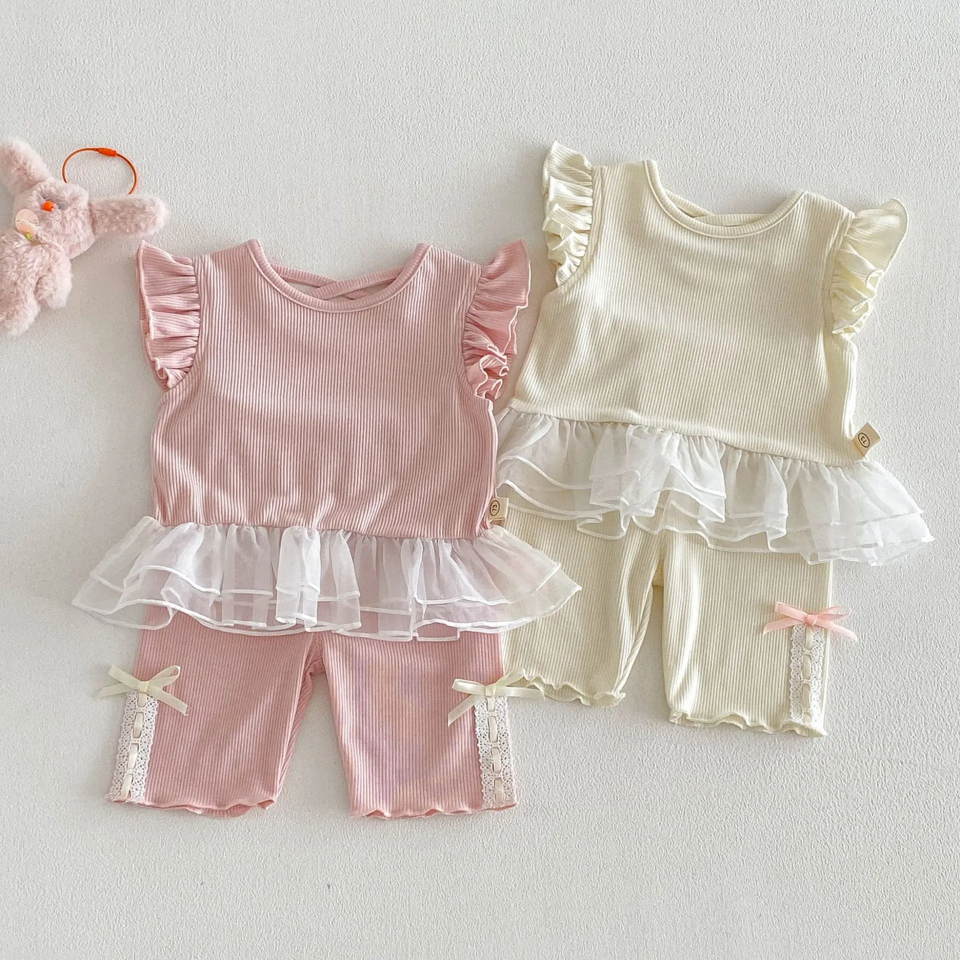 

Модный летний комплект для девочек в корейском стиле 2026: новая стильная блузка с рукавами-крылышками и шорты с бантом, две части