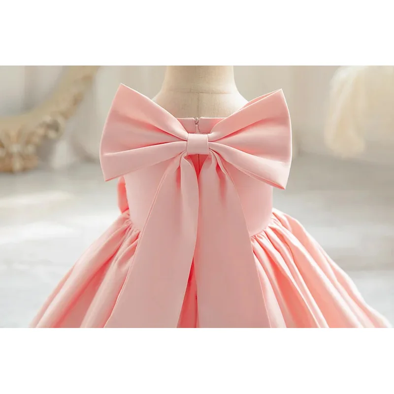 تتعثر فتاة صغيرة فوق سن 1 سنة مع فستان فيونكة كبيرة، فستان غسيل فتاة وردي، ملابس أطفال رسمية لعيد الميلاد