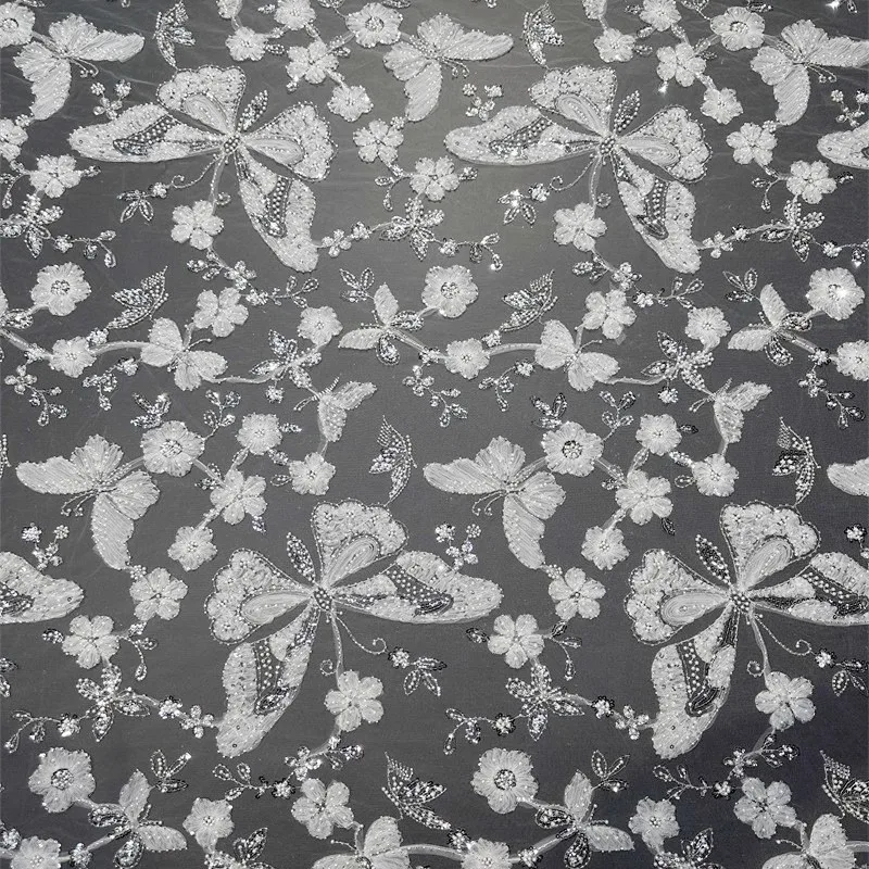 

Full-width heavy white sequined floral beaded butterfly pleated lace fabric with pearl embellishments