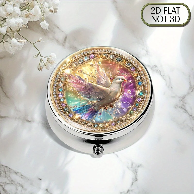 A portable round metal pill organizer with a three-compartment design, featuring a vibrant crystal dove set in a gold frame, adorned with gemstones and diamonds