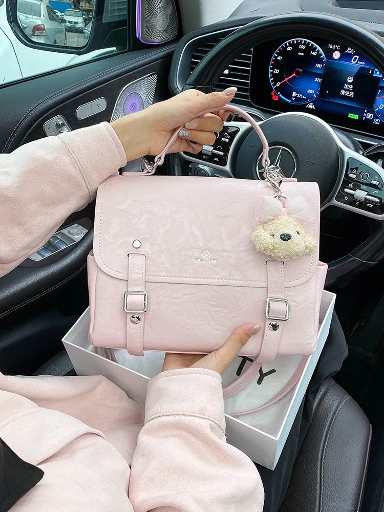 

Роскошная и популярная сумка-мессенджер с изящным мультяшным кулоном и высококачественной кожей, женский дорожный рюкзак в стиле преппи 2026 года