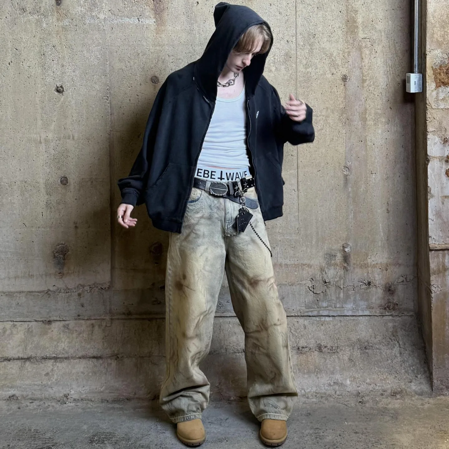 Latui Atelier new collection features distressed washed stained hand-painted denim pants with a wide-leg design and frayed edges