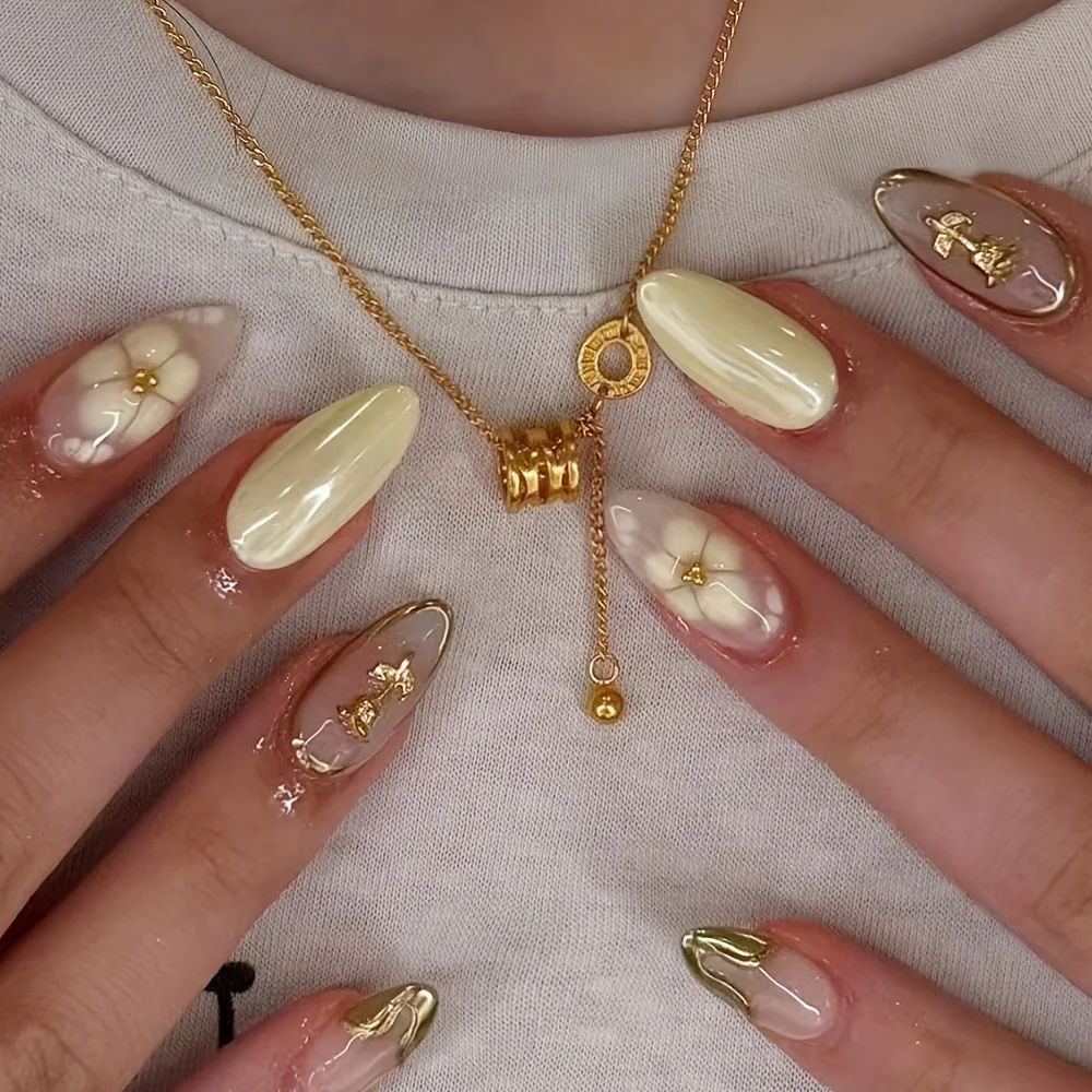 

24pcs Long Almond Press-On Fake Nails, Featuring a Creamy Yellow Paired with a Sheer Nude Ombre Base, Accented with Hand-painted Flowers, Foil-stamped Roses, and Metallic Lines. They Exude a Gentle yet Noble and Refined Aura.