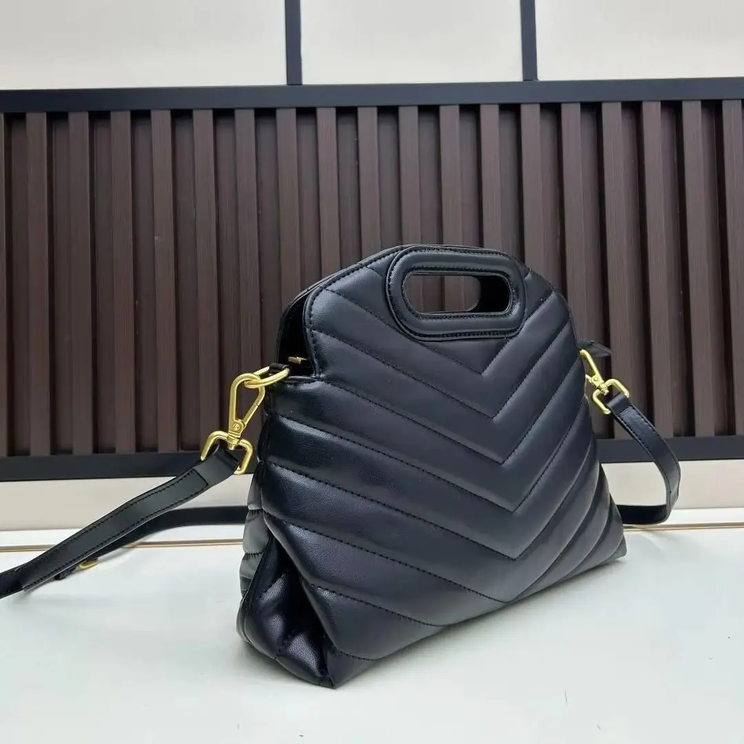 

Deep black leather handbag with V-shaped quilting, a cut-out top handle and detachable gold-tone hardware strap.