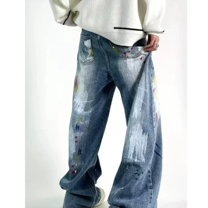 Calças jeans de perna larga estilo hip-hop com estampa de grafite e tinta, inspiradas nas ruas europeias e americanas.
