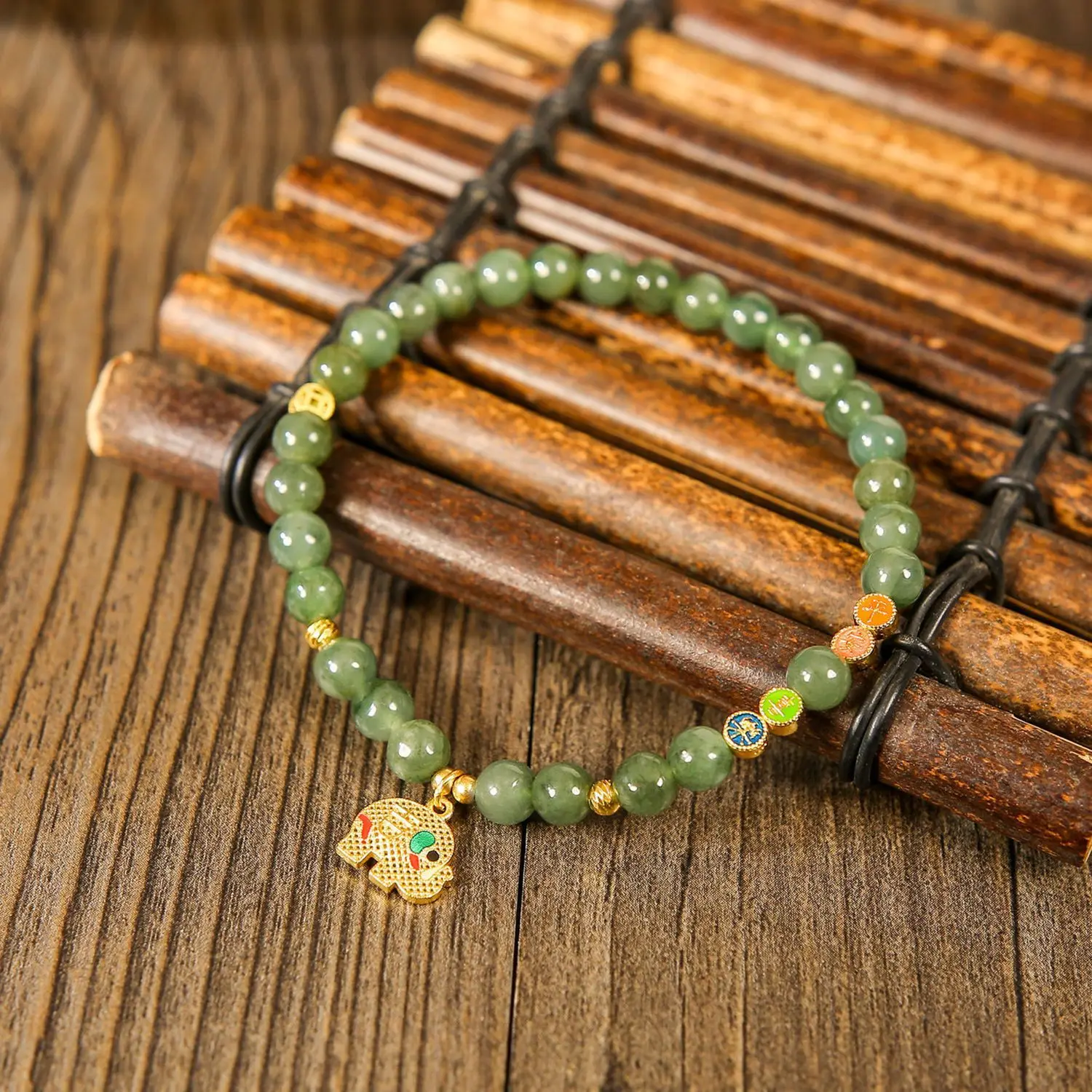 

Браслет из зеленого нефрита Хэтянь с бусинами и золотой подвеской в виде слона – украшение в спокойном восточном стиле
