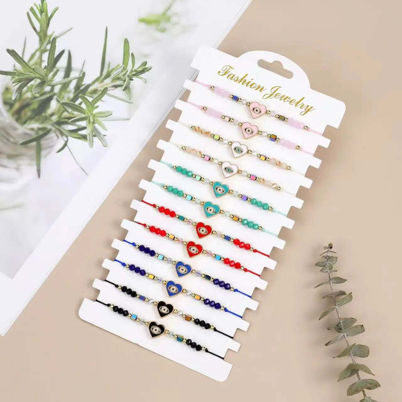 Un juego de 12 piezas de pulsera ajustable de moda europea y americana tejida con cristales de mal de ojo y corazón que gotea aceite