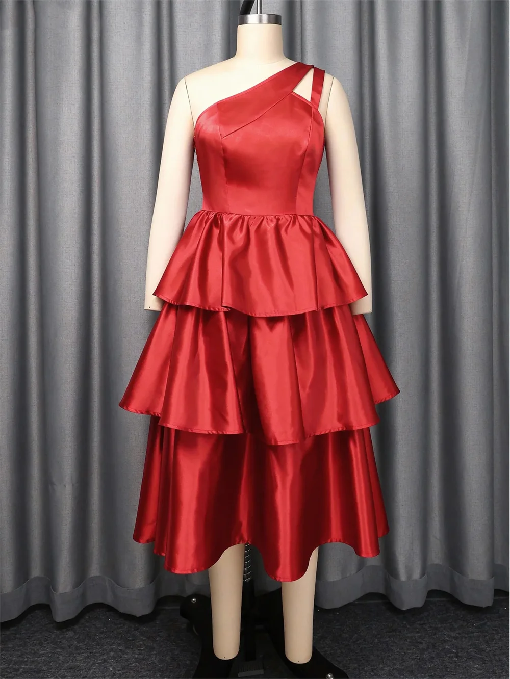 Vibrante vestido rojo de un solo hombro con falda escalonada y un acabado satinado brillante. Personalizable para crear tu producto exclusivo