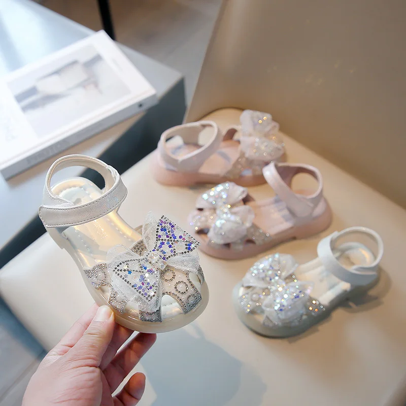 

2025 New Girls Sandals Summer New Pink Bow Flash Diamond Baotou Girls Shoes Beige Fashion Non-slip Kids Baby Shoes Sandals