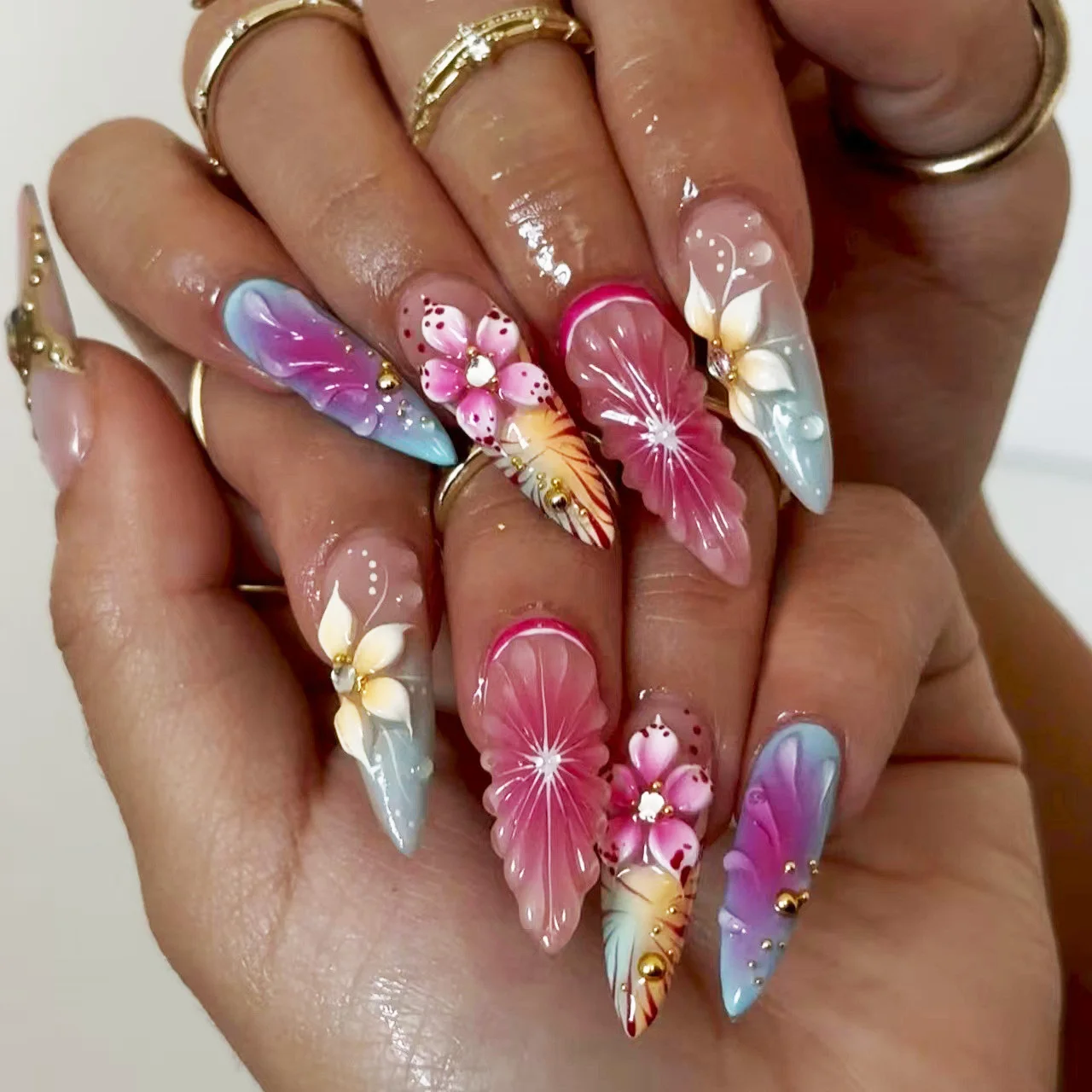 Unghie finte 3D sfumate rosa viola verde blu arancione con fiori in rilievo, frutta, strass metallici, punte medie, unghie finte a pressione.