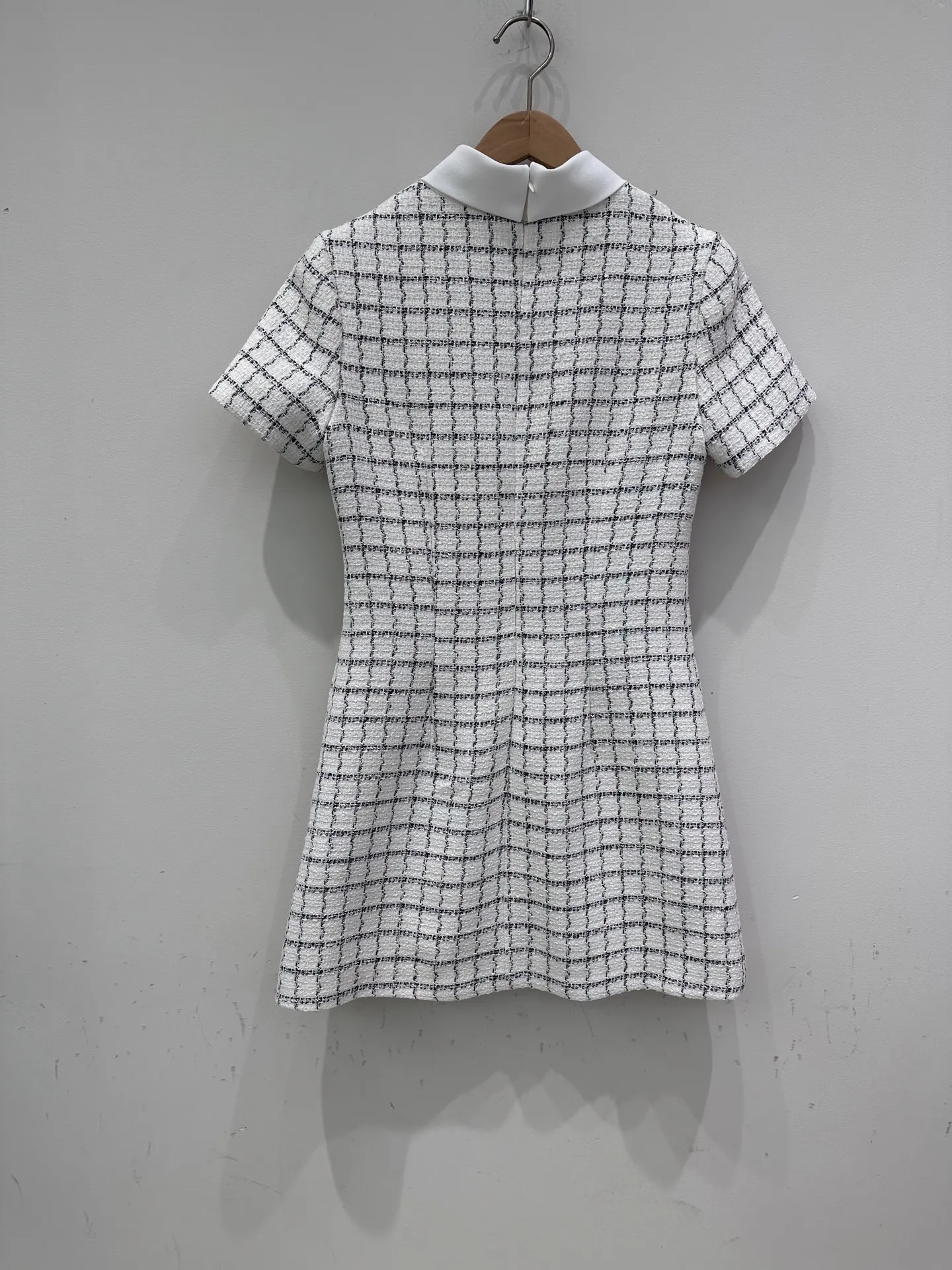 Een afslankende en nauwsluitende jurk met enkele rij knopen, een vleugje elegantie en een korte rok voor de herfst van 2025