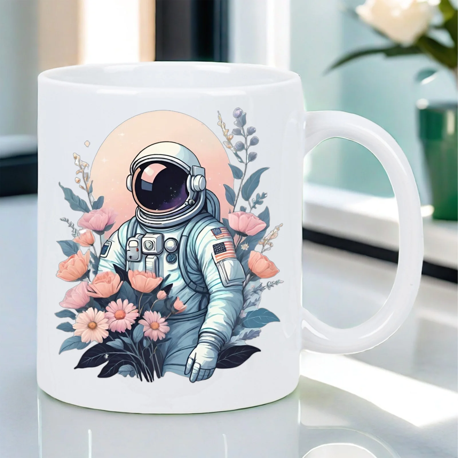 This white ceramic mug features a cosmic garden astronaut design and is suitable for everyday office use.