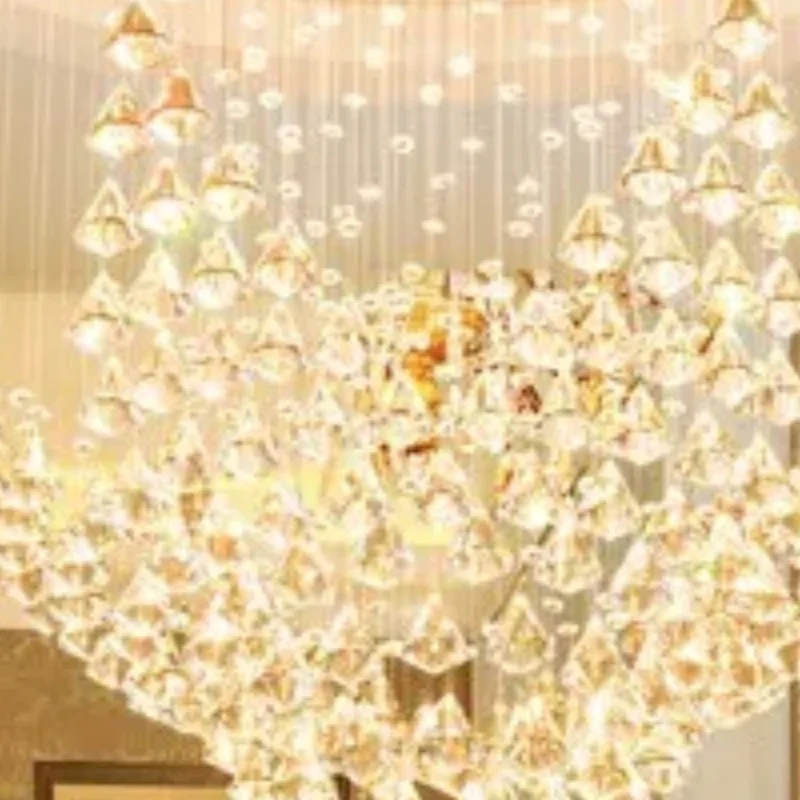 Crystal chandelier in the living room is round. Long chandelier for the staircase in the villa duplex. Creative and individual c