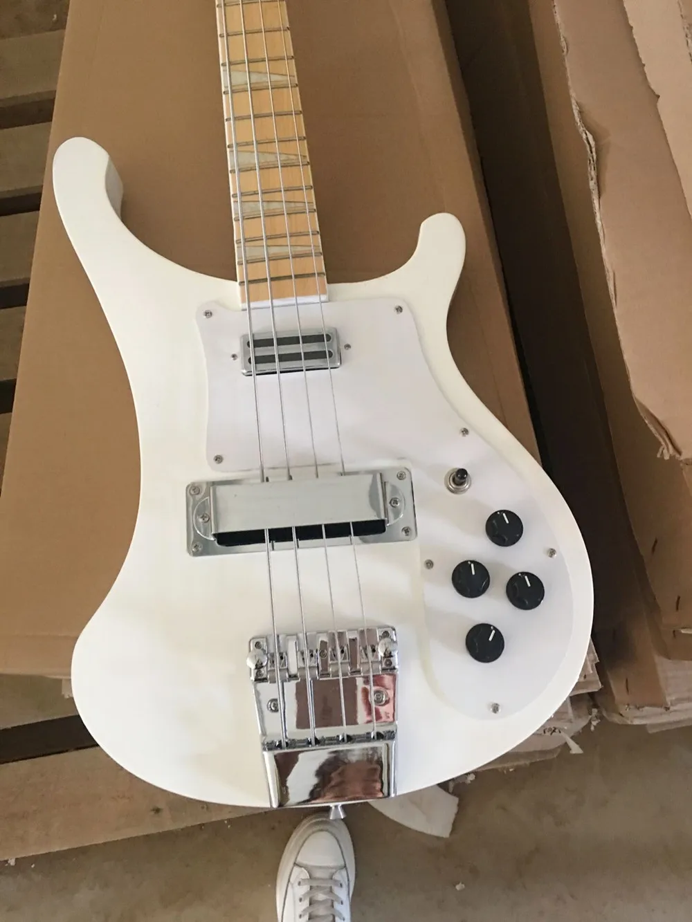 

4-струнная электрическая бас-гитара с белым корпусом и кленовым грифом, хромированная фурнитура, обеспечивающая настройку