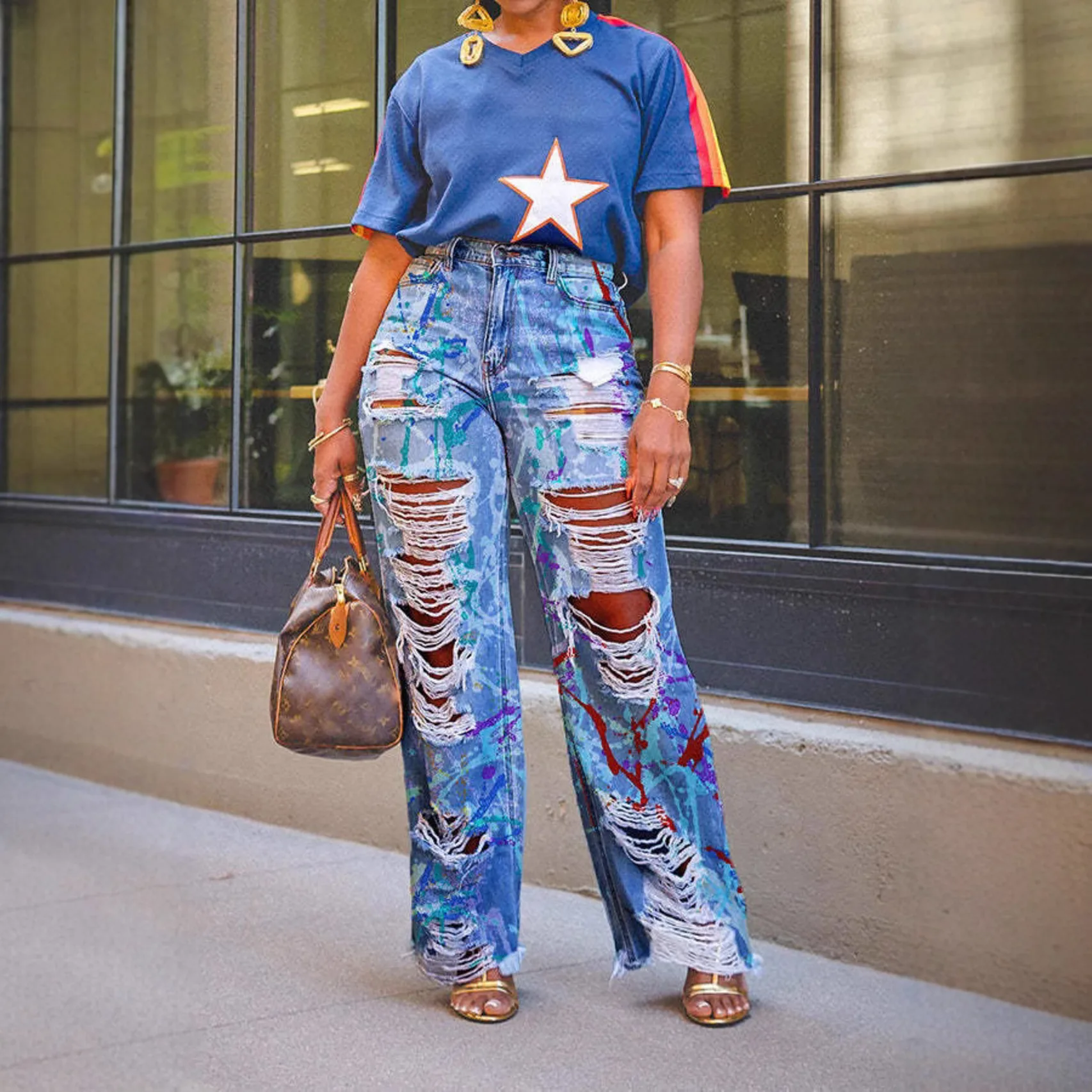 Celana jeans lurus robek dengan motif grafiti yang individual dan modis.