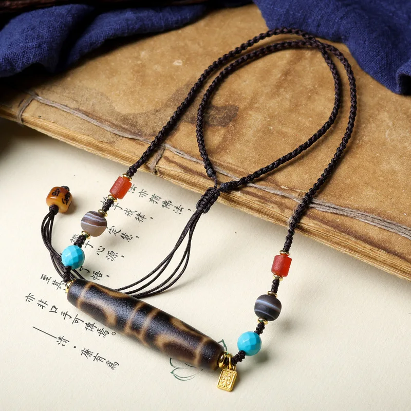 Hand-woven black and gold Tibetan-style necklace featuring a Dzi bead pendant a unique ethnic-inspired design for sweaters