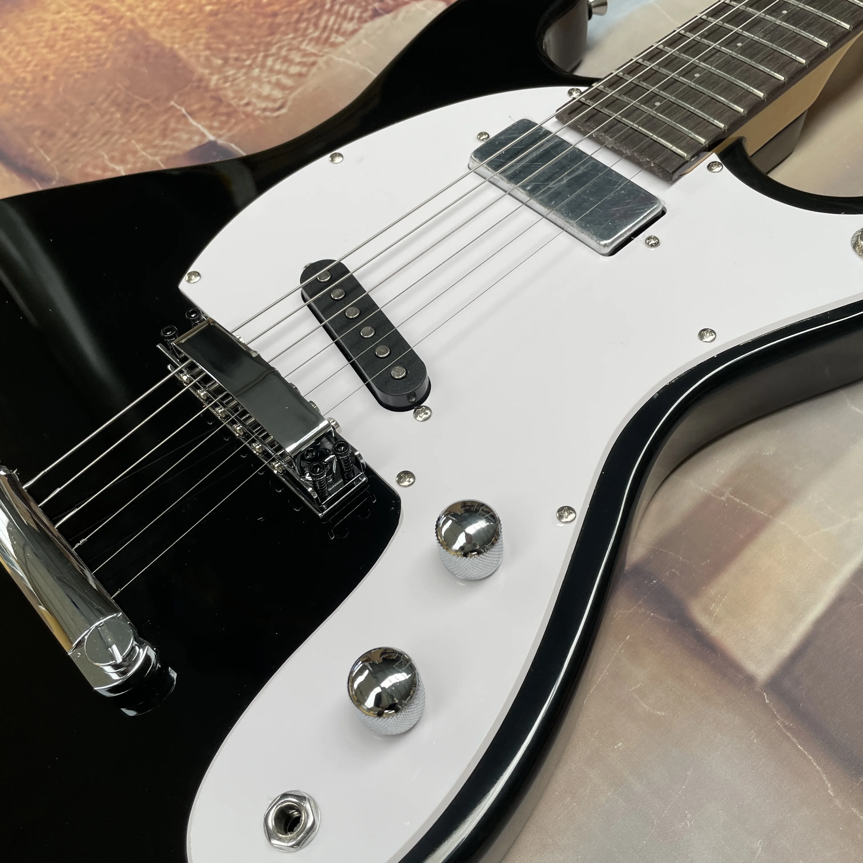 Black 6-string electric guitar with silver hardware, white pickguard,and rosewood fretboard guitars—ideal for beginners guitarra