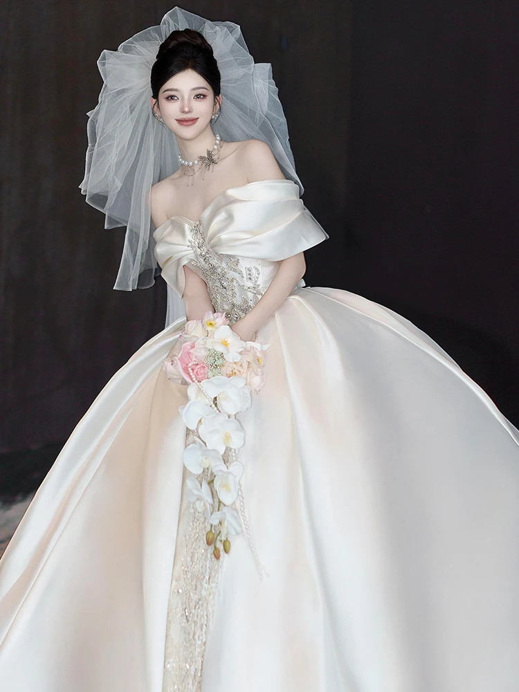 

Свадебное атласное платье для невесты с одним открытым плечом, поясом, бриллиантовыми украшениями, тяжелой вышивкой и длинным шлейфом