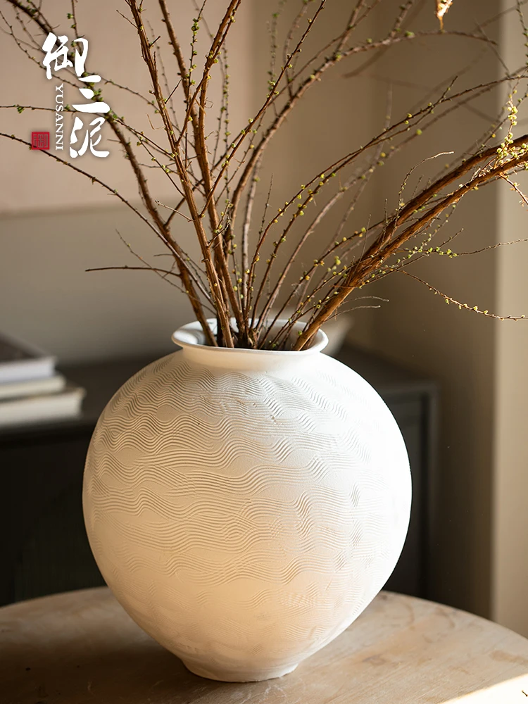 

Hand-drawn coarse pottery vase, white moon jar with dried flower ornament, water-raised flowers in the living room