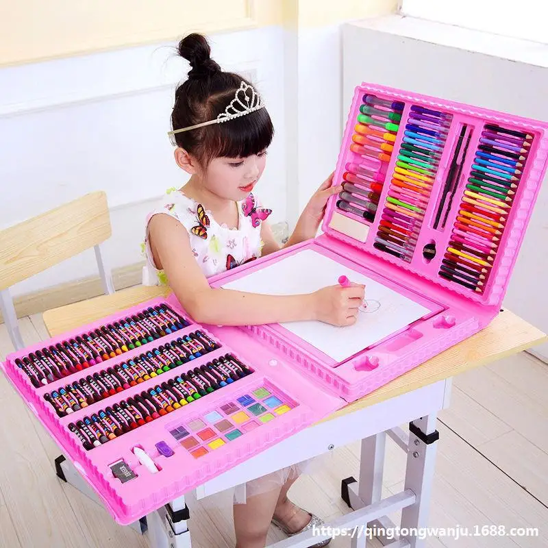 Child drawing with the art kit on a table