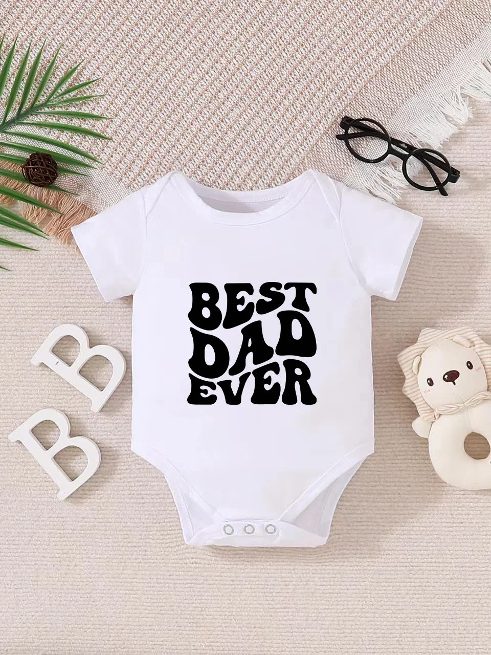 Playful letter-printed baby short-sleeve triangle bodysuit. Button closure for easy dressing, machine washable
