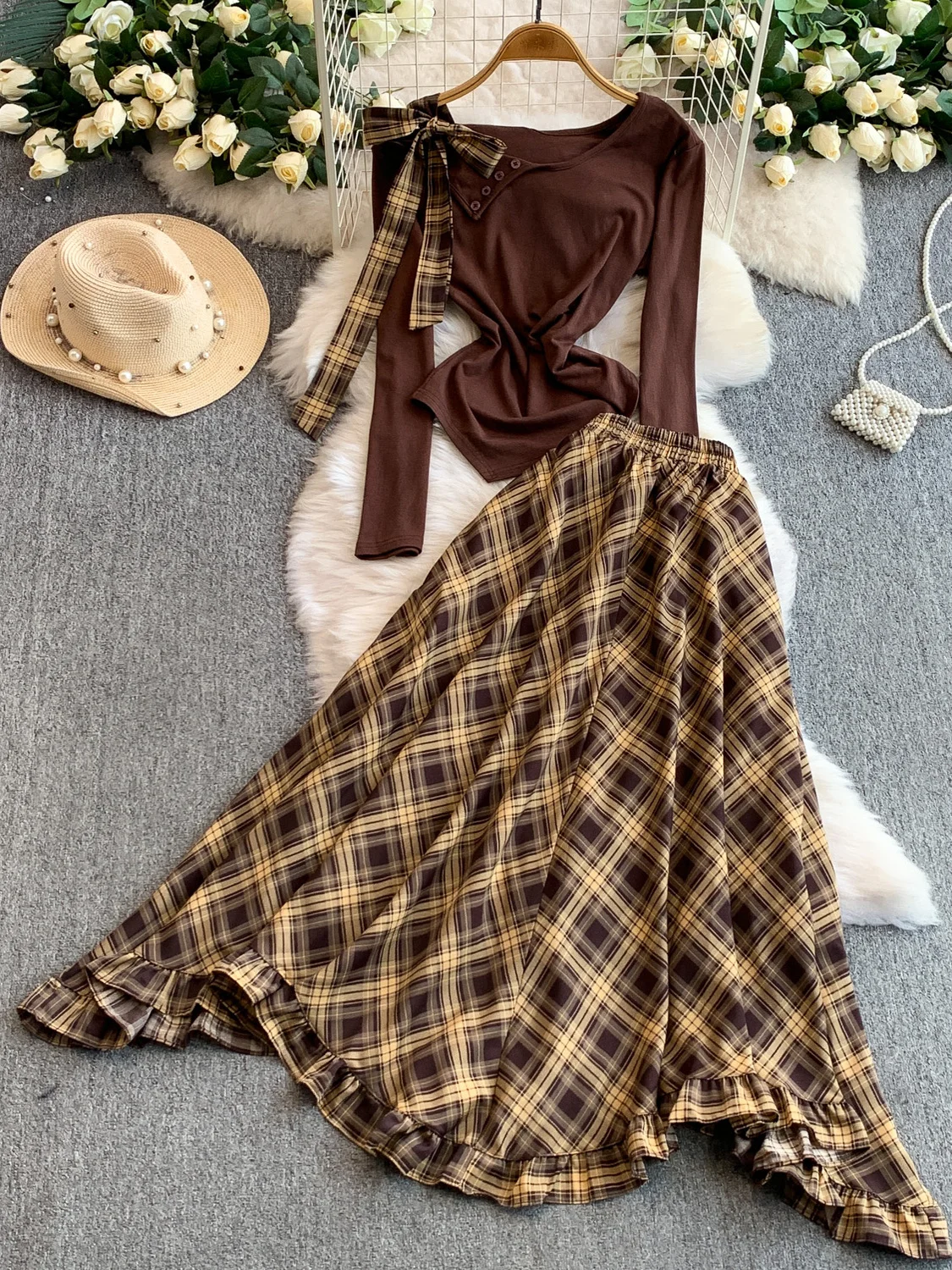 Conjunto de duas peças: Blusa e estilo irmã com babados e alça assimétrica e saia longa com estampa xadrez.