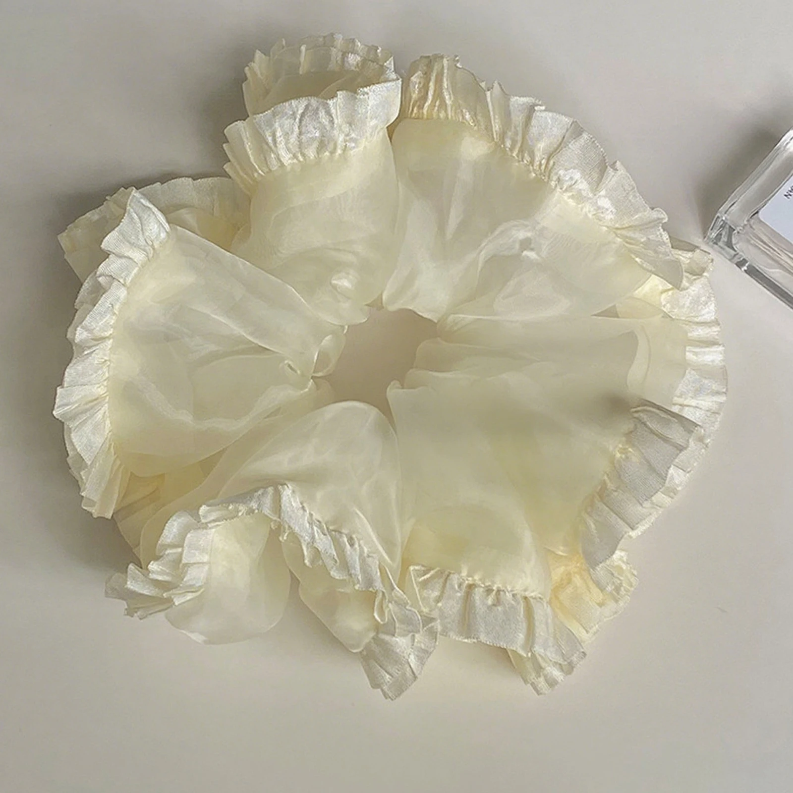 

Нежная объемная гумка из органзы цвета шампанского. Женская мода и простые аксессуары для волос.