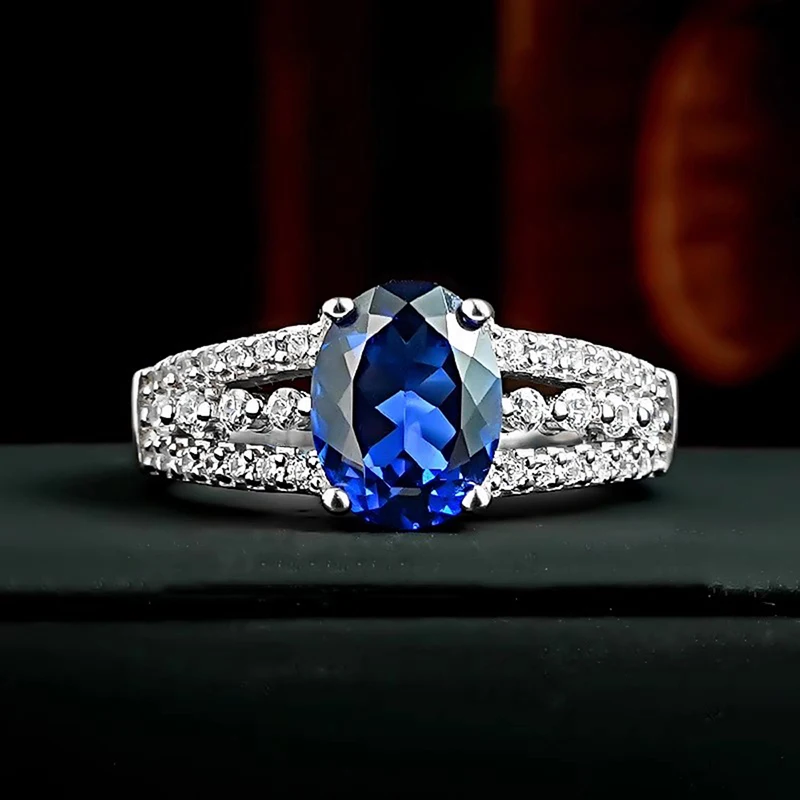 Huitan Eleganter silberfarbener Ring für Damen, edles Hochzeits-Modeaccessoire mit blauem ovalem CZ, ausgefallenes Verlobungsschmuck-Geschenk