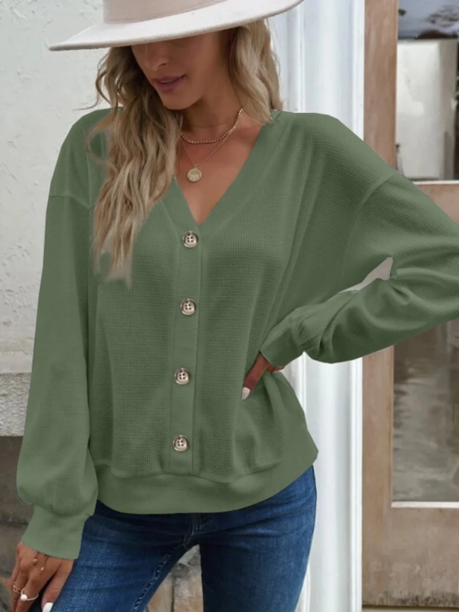 قميص نسائي فضفاض بأكمام طويلة وياقة على شكل V، مريح وعصري بلون واحد، مناسب للارتداء في الشارع خلال فصل الخريف، مع تفاصيل الأزرار