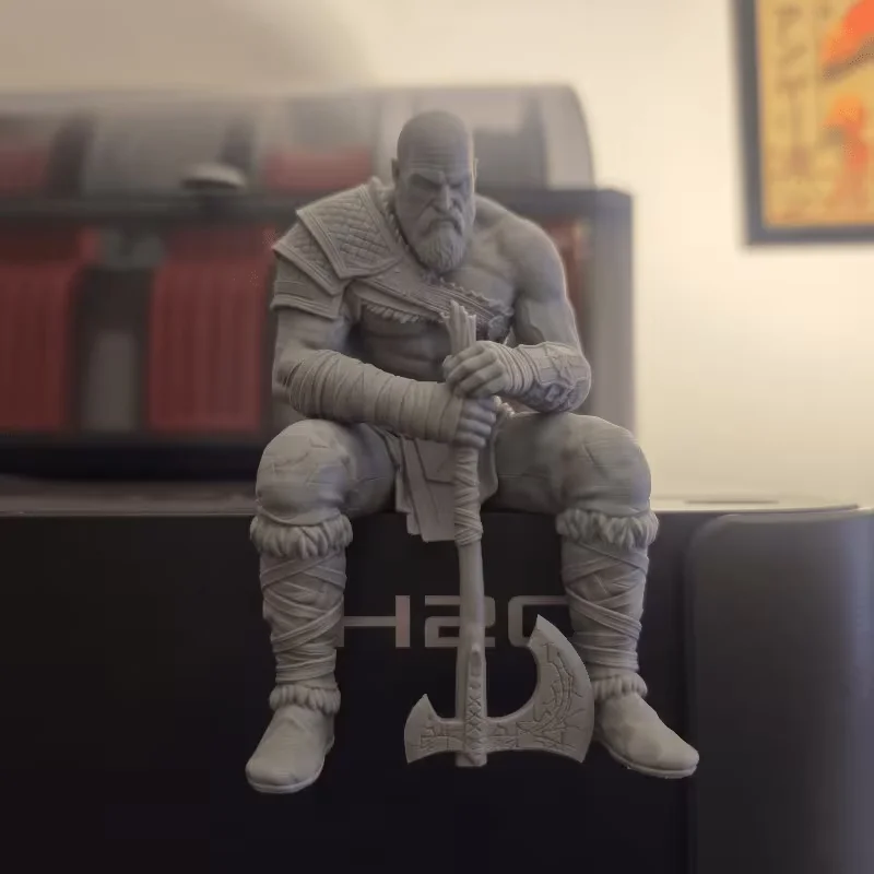 Uma estátua única de guerreiro nórdico musculoso sentado em pedestal, e uma estátua impressa em 3D de um guerreiro melancólico barbudo segurando uma machado.