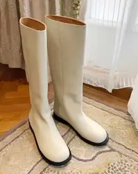 Zimowy biały czarny miękki skórzany okrągły nosek płaskie buty do kolan kobiety moda rura Slip On długi, swobodny Botas buty