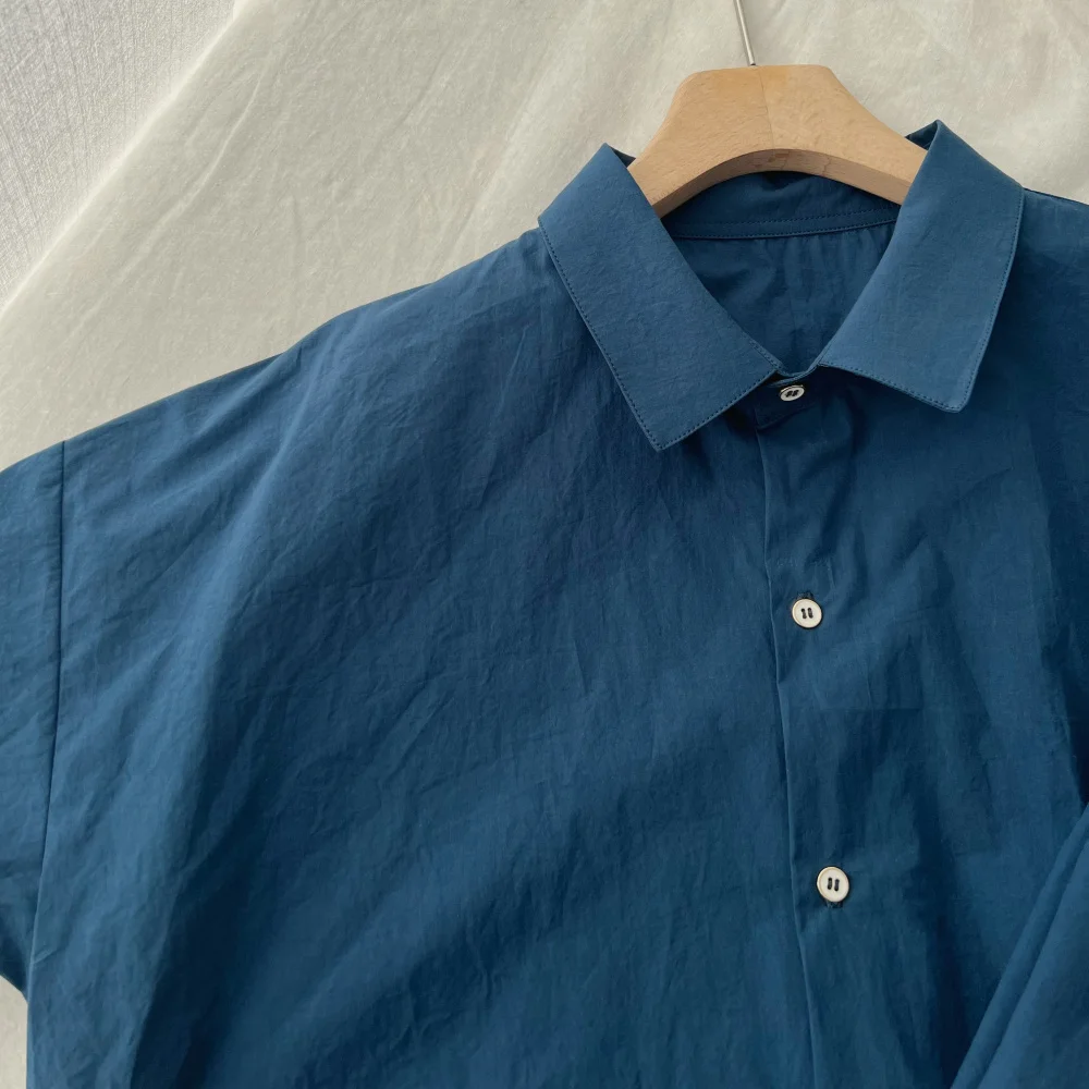 Luźna damska koszula bawełniana w kolorze niebieskim, wysoka ilość włókien, wyprana, w stylu lazy, długi rękaw, kołnierzyk, regularny krój, jednolity kolor.