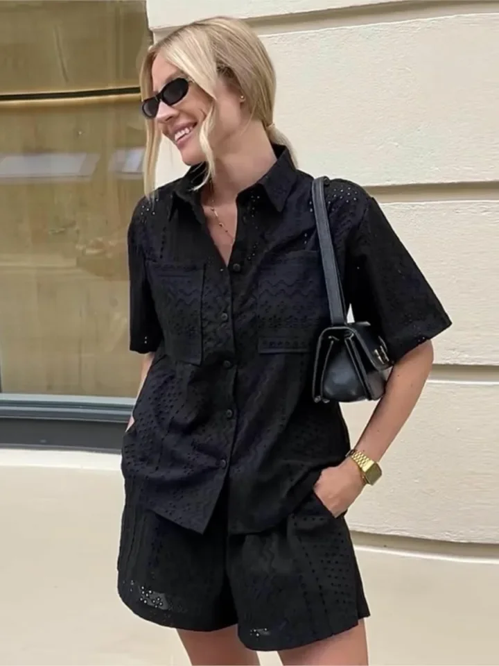 Modny letni komplet dwuczęściowy damski: koronkowa bluzka z krótkim rękawem i ażurowymi detalami oraz krótkie spodenki, damski letni zestaw dwuczęściowy.